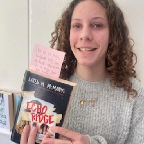 Elev fra 7. klasse med bogen "Echo Ridge" i hænderne.