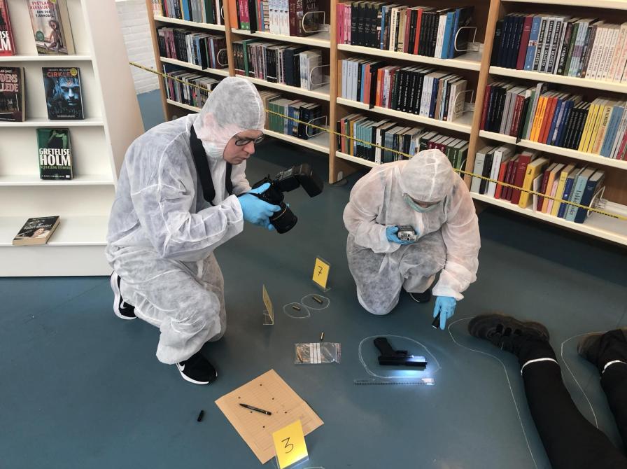 To personer leger retsmedicinere på et gerningssted